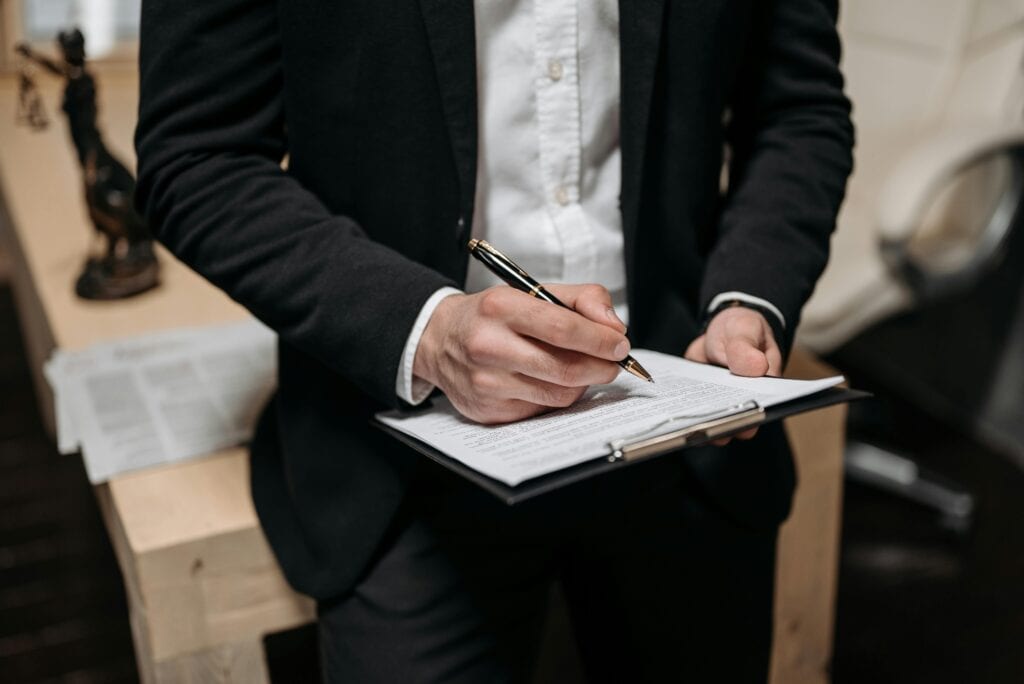 Business professional writing on clipboard, symbolizing SAP documentation and evaluation processes.