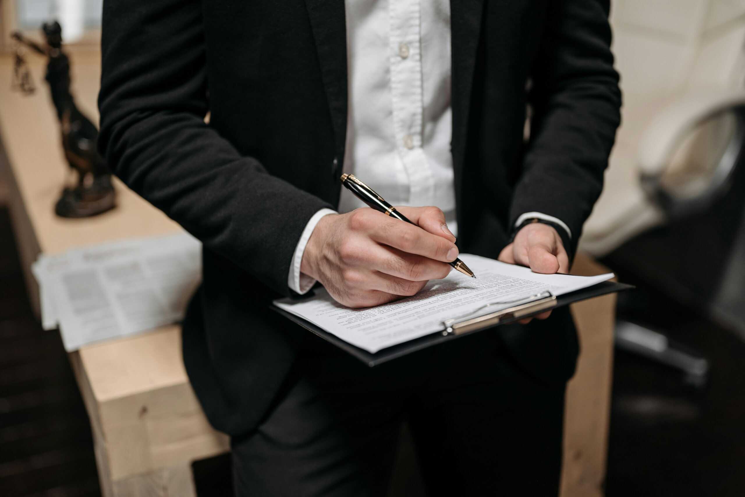 Business professional writing on clipboard, symbolizing SAP documentation and evaluation processes.